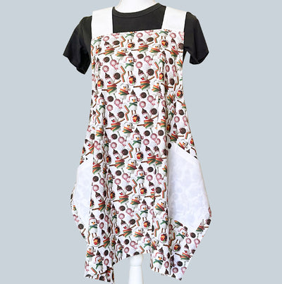A whismsical holiday crossed apron.  Printed with full color photo pattern of snowmen made of marshmellows with candy cane  from Red Bird's House. Photography by Pauline Stevens.  100% cotton. One size fits most.