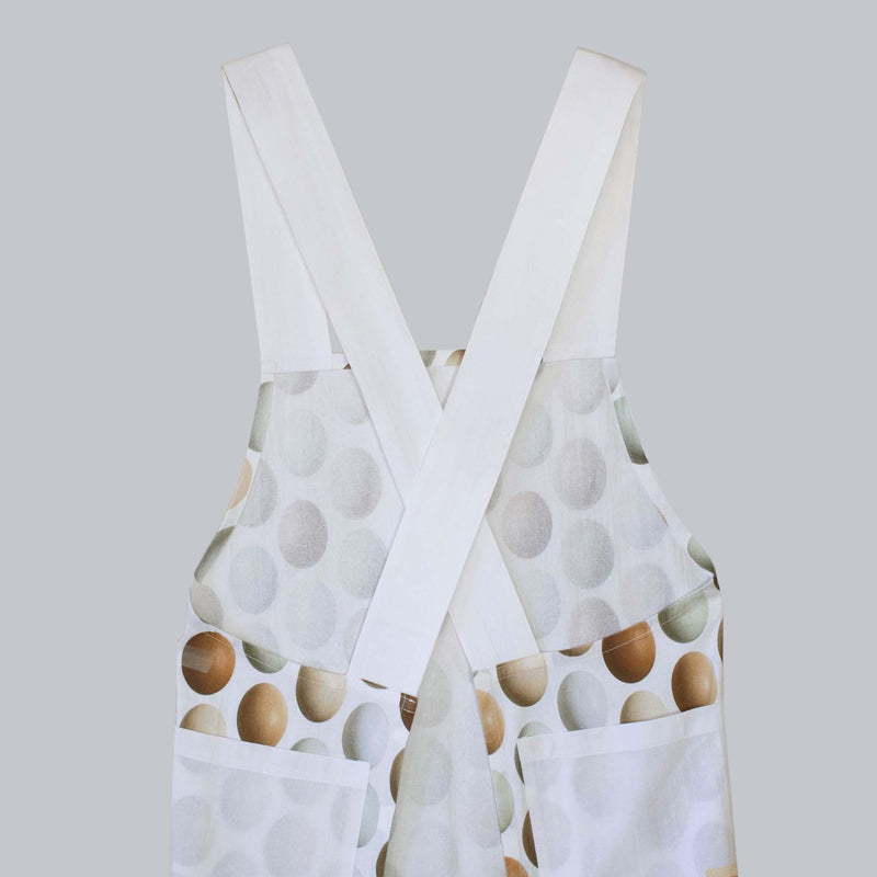  With its eye-catching criss-crossed design in the back and practicality, our cotton apron is a true kitchen essential. Whether you're a passionate baker, an aspiring chef, or a home lover seeking the perfect blend of style and functionality, this apron is sure to impress. Elevate your cooking experience today!  Features  Size: 35"x 27"  Straps-30"  Pockets: 8"  One size fits most Original photography by Pauline Stevens Photography Maxchine wash/Tumble dry No bleach