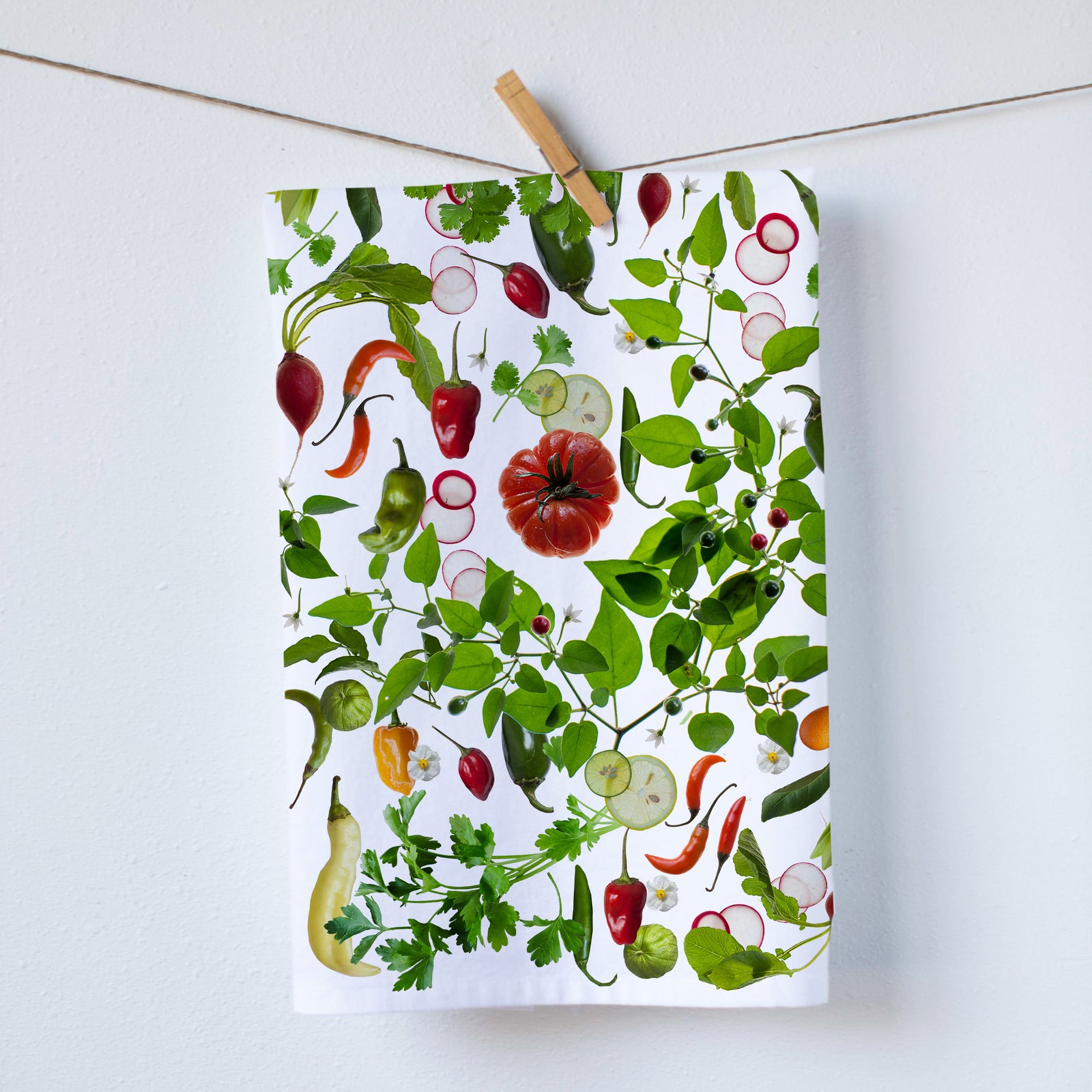 A white cotton kitchen towel printed with a designof peppers and tomato. size 19x28