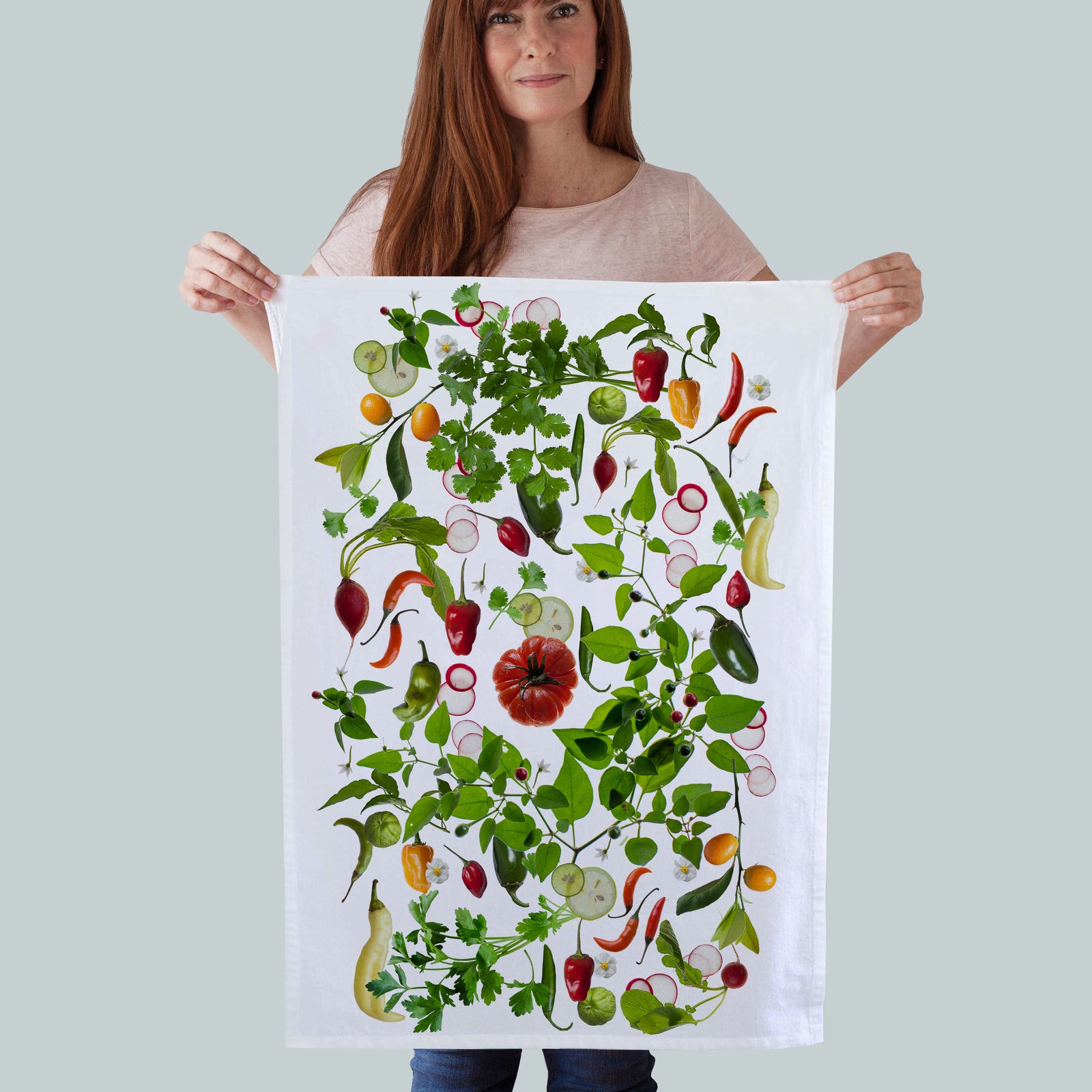 A white cotton kitchen towel printed with a designof peppers and tomato. size 19x28